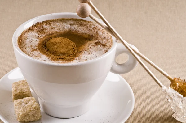 卡布奇诺咖啡杯子与棕色焦糖糖在带纹理的背景 — 图库照片