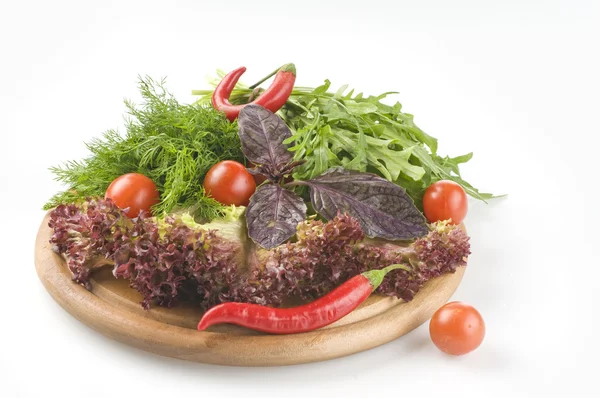 Herbes et légumes crus frais sur planche à découper sur blanc — Photo