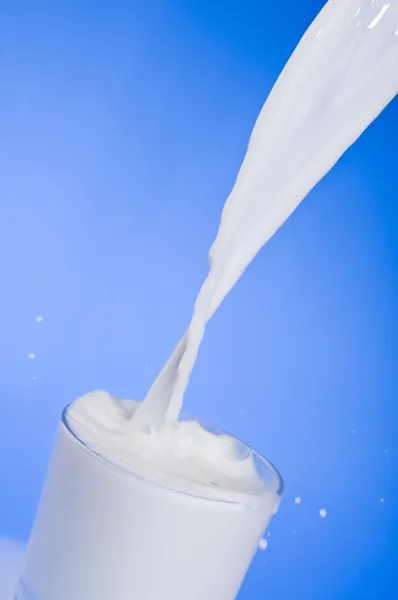 Derramando leite em um copo — Fotografia de Stock