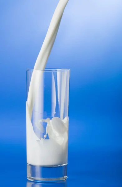Derramando leite em um copo — Fotografia de Stock