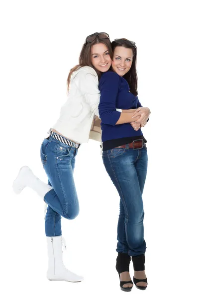 Twee meisjes vrienden in spijkerbroek geïsoleerd op wit — Stockfoto