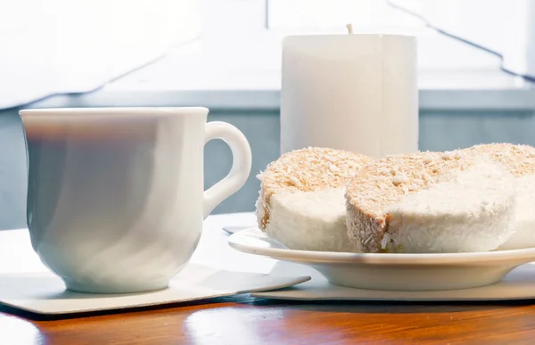 Cappuccino and cake, the candle in the background. — Stock Photo, Image