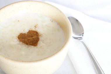 Bowl of rice pudding and cinnamon heart clipart