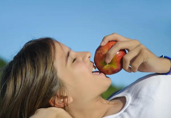 Дівчина з'їсти яблуко — стокове фото