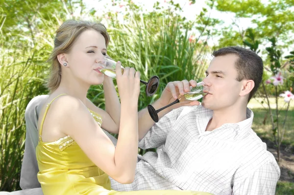 Ungt par firar med champagne tillsammans, utomhus — Stockfoto