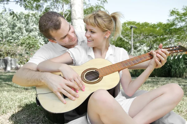 Casal com uma guitarra no parque — Fotografia de Stock