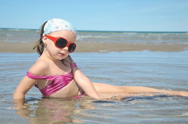 Menina bonita encontra-se no litoral — Fotografia de Stock