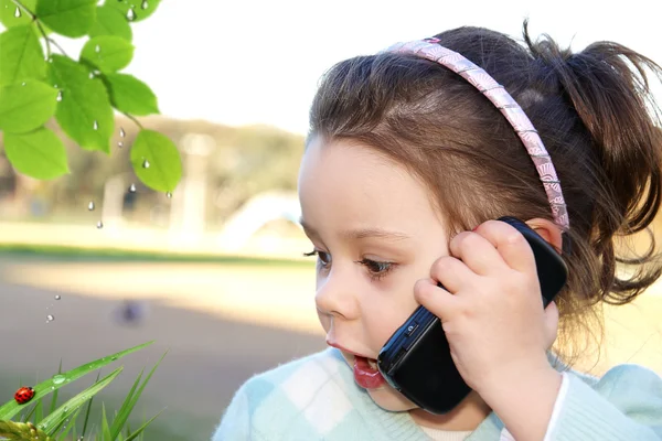 Meisje zit buiten met communicator — Stockfoto