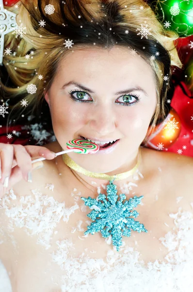 Christmas girl with candy in snow — Stock Photo, Image