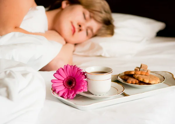 Een mooie vrouw met ontbijt op bed — Stockfoto