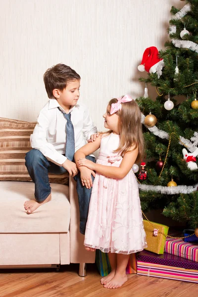 Девочка и мальчик возле елки — стоковое фото