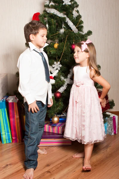 Девочка и мальчик возле елки — стоковое фото