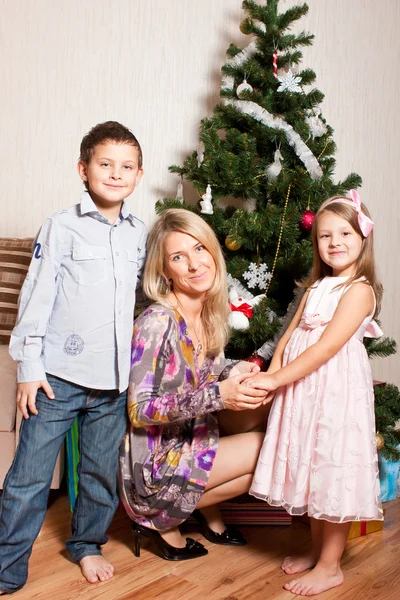 Mother and children near a fir-tree — Stock Photo, Image