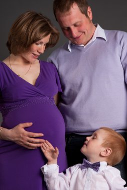 Happy family with cute boy expecting another baby clipart