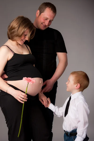 Família feliz com menino bonito esperando outro bebê — Fotografia de Stock