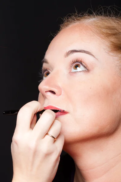 A visagiste inflicts a make-up to the woman — Stock Photo, Image