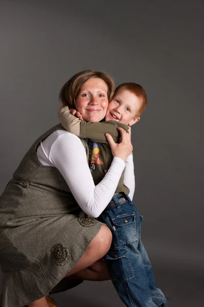 Kleiner Junge umarmt schwangere Mutter sanft — Stockfoto