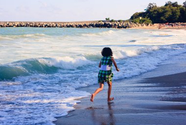 A girl hurries on the coast of black sea on a resort in Bulgaria clipart