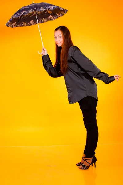 黄色の背景に傘を持つ魅力的な若い女性 — ストック写真