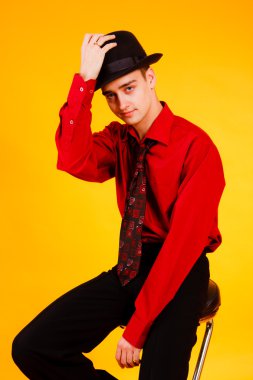 Sarı bir arka plan üzerinde şapkalı bir genç adam