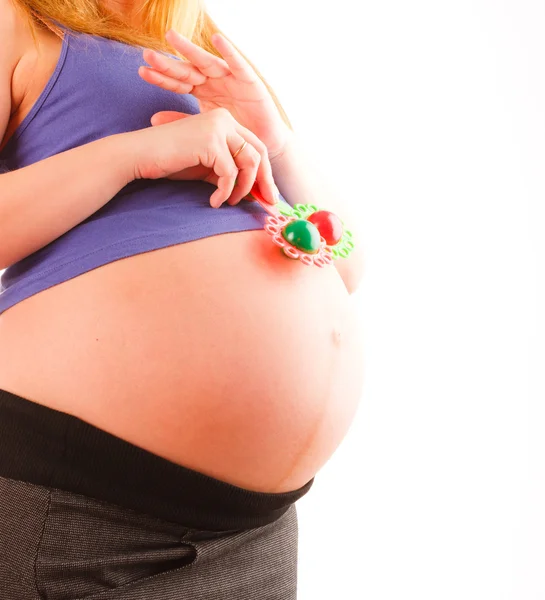 つの赤ちゃんのガラガラを保持している妊娠中の女性をクローズ アップ — ストック写真