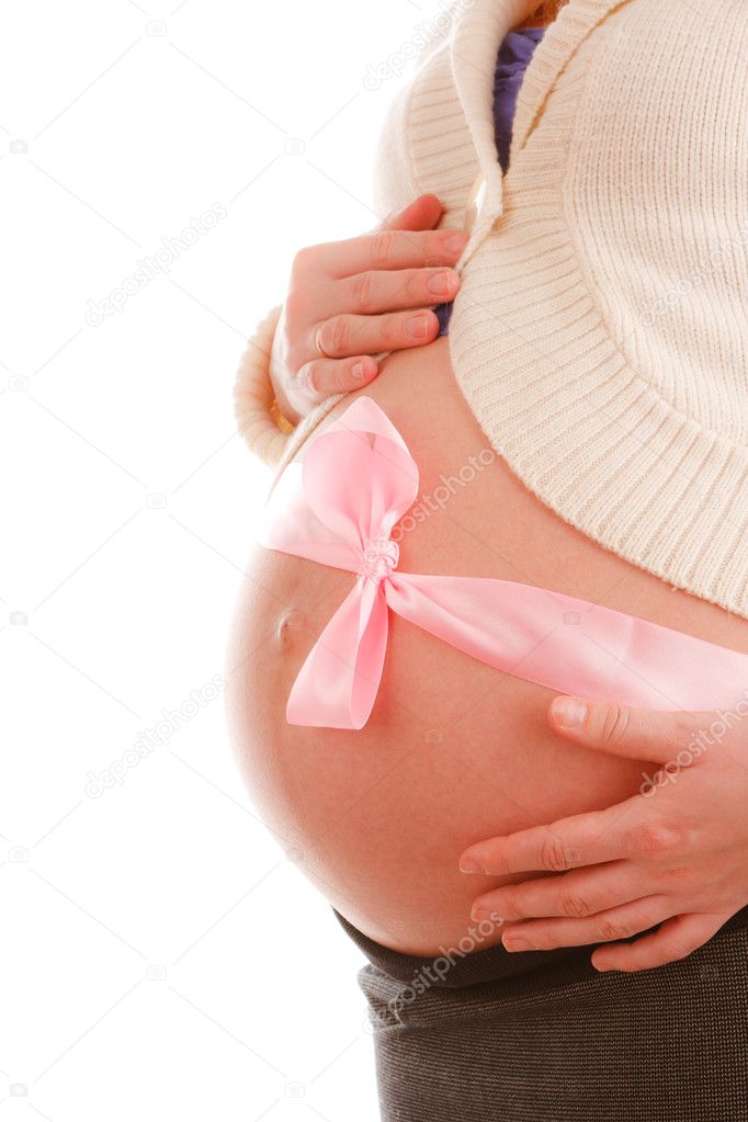 Close up of belly of pregnant woman with pink ribbon