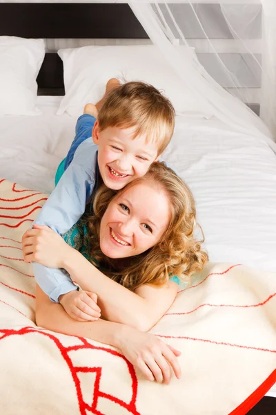 Vrouw met een zoon op een bed — Stockfoto