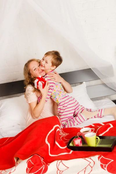 Mulher com seu filho café da manhã em uma cama — Fotografia de Stock