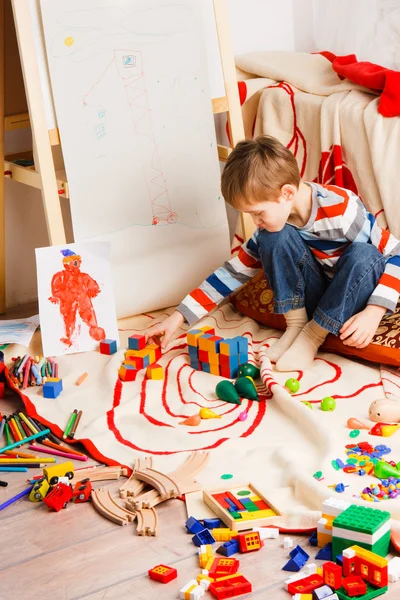 Niño en el suelo juega bloques varicolores —  Fotos de Stock