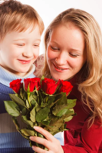 Frau mit einem Sohn und einem Strauß roter Rosen — Stockfoto