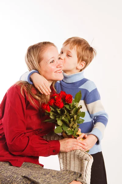 Mulher com um filho e com o buquê de rosas vermelhas — Fotografia de Stock