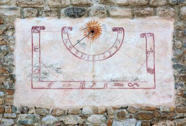 Sun dial on a wall of an old castle clipart