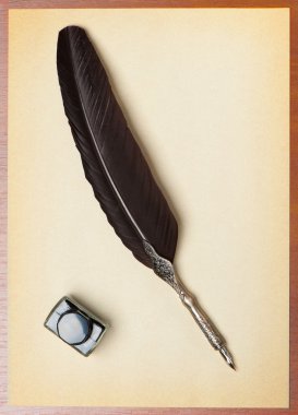 Feather quill and inkwell on an old paper clipart