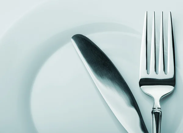 Нож и вилка на тарелке — стоковое фото