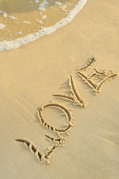 Inscription "love" on sand — Stok fotoğraf