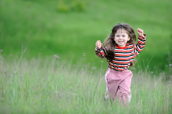 Бегущая девушка на зеленом поле — стоковое фото