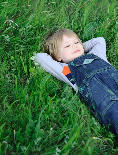 Мальчик на зеленой траве — стоковое фото