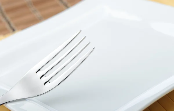 Tenedor tendido en un plato —  Fotos de Stock