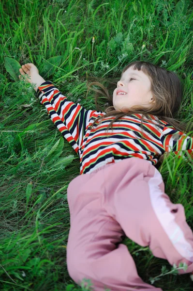 Flickan på ett grönt gräs — Stockfoto