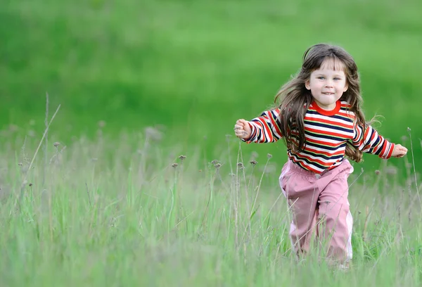 Бегущая девушка на зеленом поле — стоковое фото
