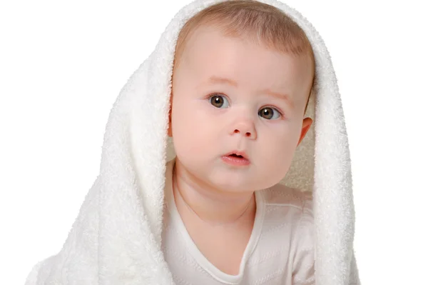 stock image The baby under a towel. Age of 8 months. It is isolated on a whi