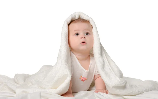 stock image The baby under a towel. Age of 8 months. It is isolated on a whi