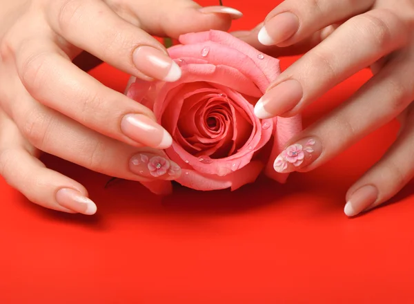 Manicure. vrouwelijke handen op rode achtergrond — Stockfoto