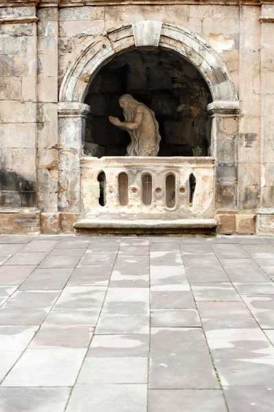 Pomnik modląc się starszy w jaskini — Zdjęcie stockowe