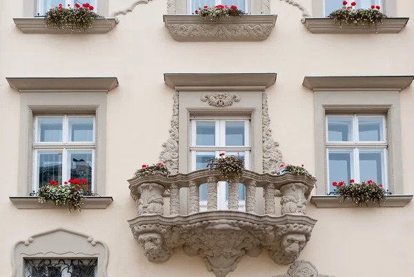 Fachada de un edificio con balcón y flores — Foto de Stock