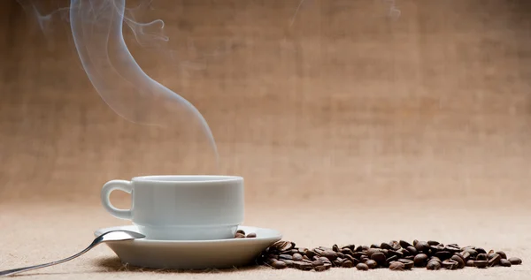 Tazza di caffè caldo sul traghetto e grani di caffè su grunge — Foto Stock