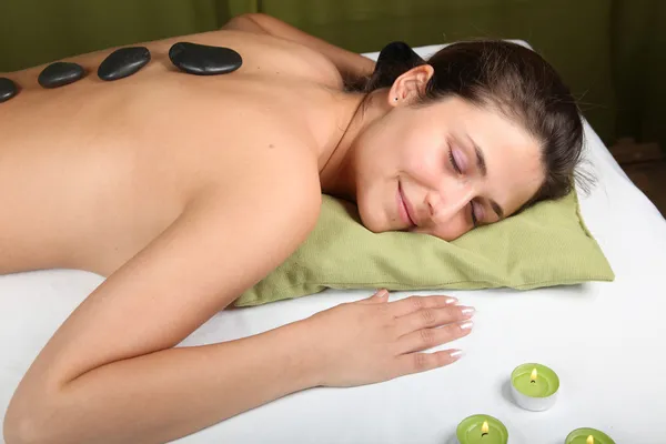 Junge Frau bekommt eine Hot-Stone-Massage lizenzfreie Stockfotos