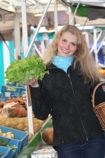 Jeune femme au marché achetant une salade — Photo