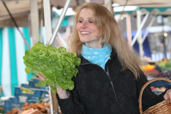 Donna sorridente al mercato con un'insalata — Foto Stock