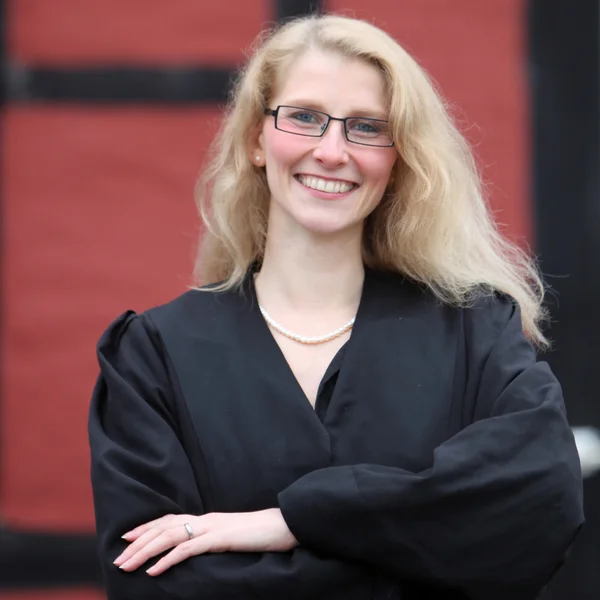 Juridikstuderande eller advokat i en mantel leende — Stockfoto